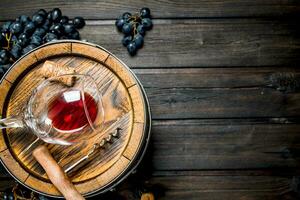 Wine background. Barrel with red wine and grapes. photo