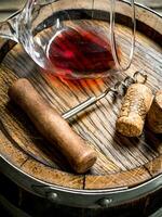 Wine background. A glass of red wine on an old barrel. photo