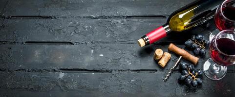Wine background. Red wine with grapes and corkscrew. photo