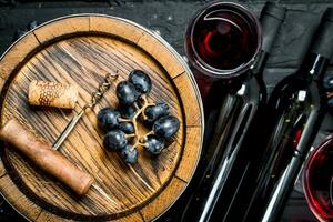 vino antecedentes. rojo vino con uvas y un antiguo barril. foto