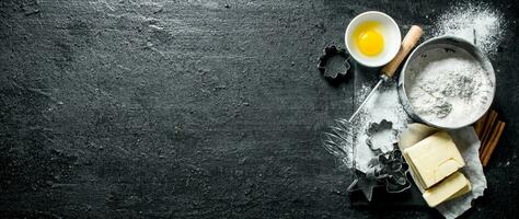 Baking background. Flour with egg, butter and various forms for baking. photo