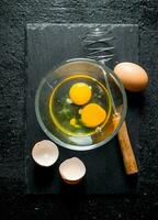 Eggs in bowl with whisk. photo