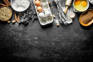Baking background. Flour with cocoa, eggs and baking forms of the dough. photo