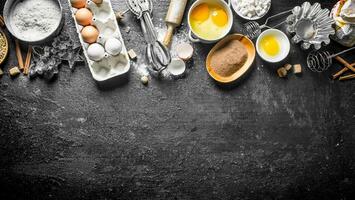 Baking background. Flour with cocoa, eggs and baking forms of the dough. photo
