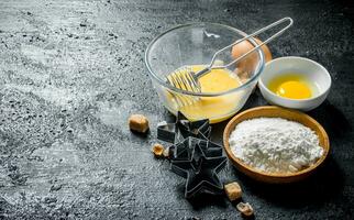 Flour with eggs and forms for the preparation of cookies. photo