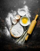 Flour with egg and a rolling pin. photo