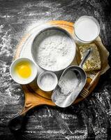 Baking background. Flour with honey, milk and egg on the cutting Board. photo