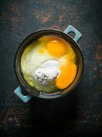 Flour with eggs in the pan. photo