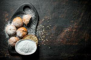 Fresh buns with flour and grain in the bowls. photo