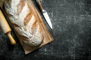 Rye bread with knife and rolling pin. photo