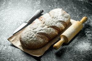 Rye bread with knife and rolling pin. photo