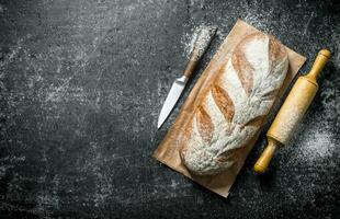 Rye bread with knife and rolling pin. photo