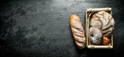 Assortment of different types of bread in the basket. photo