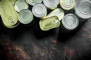 Assortment of various closed tin cans with canned food. photo