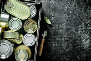 Closed metal cans with canned food in the box. photo