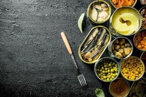 Open cans of mushrooms, pineapples, corn and canned fish. photo