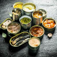 Assortment of different kinds of canned food in cans. photo