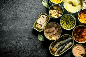 Assortment of different kinds of canned food in cans. photo