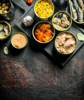 Assortment of various canned food in open cans. photo