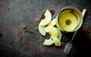 Open tin can with canned pineapple. photo