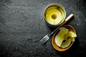 Canned pineapples on a plate with a fork. photo