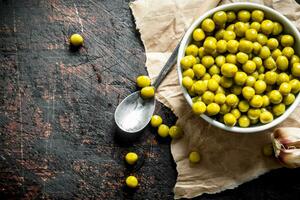 Canned green peas in a bowl on paper. photo