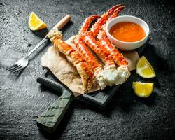 Crab on paper with lemon slices and sauce. photo