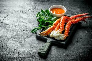 Crab on a cutting Board with parsley and sauce. photo