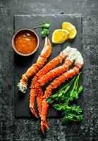 Crab on a stone Board with sauce, parsley and lemon slices. photo