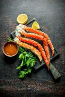 Crab on a chopping Board with parsley, sauce and lemon slices. photo