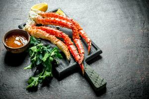 Crab on a chopping Board with parsley, sauce and lemon slices. photo