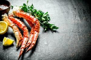 Boiled crab with herbs, sauce and sliced lemon. photo