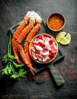 Crab and crab meat on a plate with herbs, sauce and lemon. photo