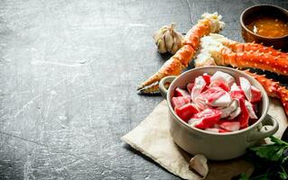 Crab meat in bowl on paper with fresh crab and sauce. photo