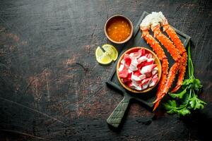 Crab and crab meat on a plate with herbs, sauce and lemon. photo