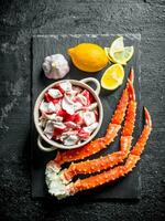 Crab meat and fresh crab on a stone Board with lemon and garlic. photo