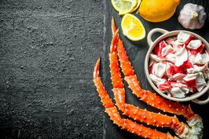 Crab meat and fresh crab on a stone Board with lemon and garlic. photo