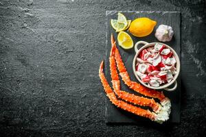 Crab meat and fresh crab on a stone Board with lemon and garlic. photo