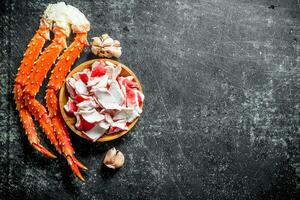 Crab meat on a plate and a fresh crab with garlic cloves. photo