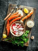 Crab meat and fresh crab on tray with sauce, lemon slices and parsley. photo