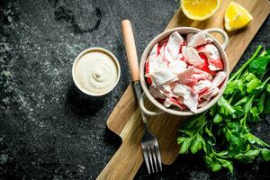 Crab meat in bowl on cutting Board with fork. photo