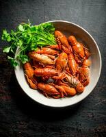 Boiled crayfish in a bowl with parsley. photo