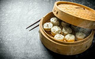 Freshly cooked manta dumplings in a bamboo steamer. photo