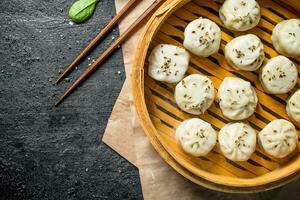 Freshly cooked manta dumplings in a bamboo steamer. photo