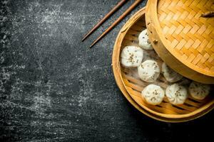 Freshly cooked manta dumplings in a bamboo steamer. photo