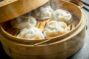 Hot dumplings manta in a bamboo steamer. photo