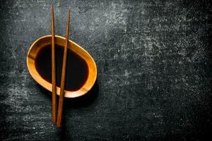 Soy sauce in a bowl with chopsticks. photo