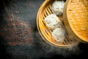 Hot dumplings manta in a bamboo steamer. photo