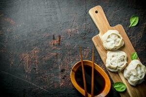 Dumplings manta on a cutting Board with soy sauce. photo