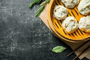 Fresh dumplings of manta with meat in a bamboo steamer. photo